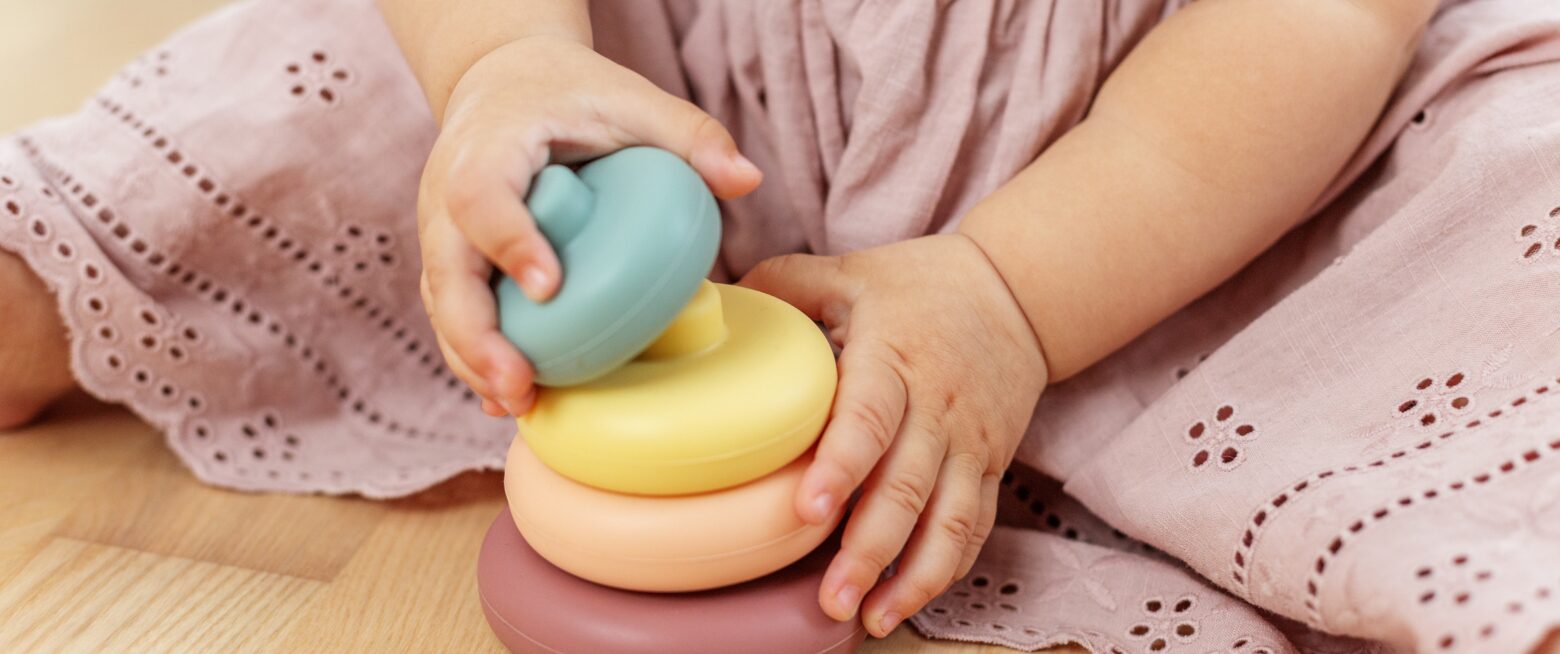 Close up of baby hands stacking wooden rings