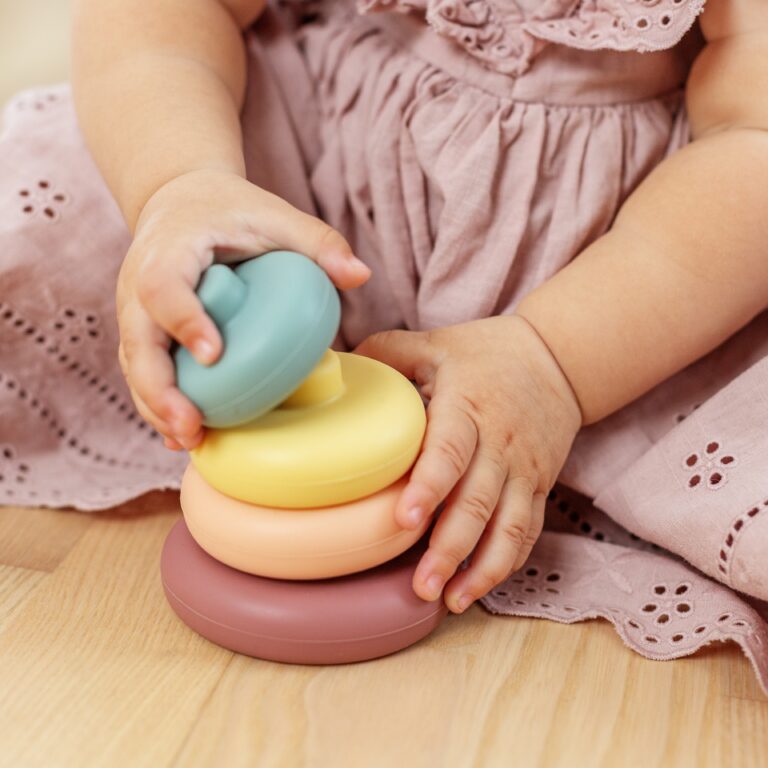 Close up of baby hands stacking wooden rings